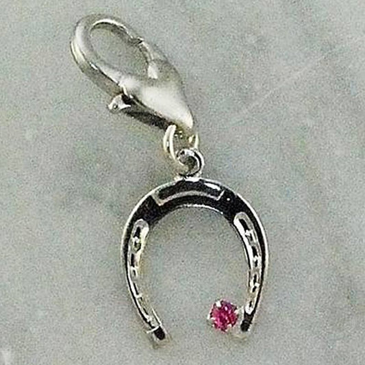 Silver horseshoe charm with pink gem, horse themed jewelry piece.
