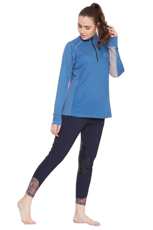 Woman modeling blue Tuffrider equestrian gear with half-zip pullover.