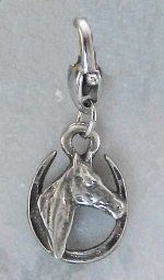 Silver horse head pendant, horse themed jewelry, on a gray background.
