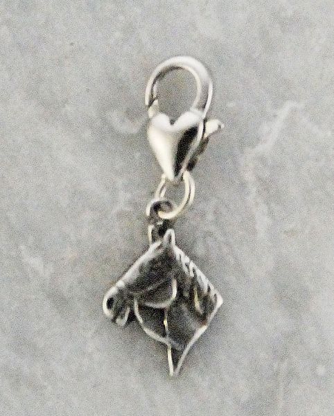 Silver horse head charm, horse themed jewelry on gray background.